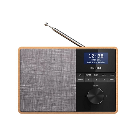 Ein braunes Holzradio mit grauem Lautsprechergitter und schwarzem Bedienfeld. Auf dem Display steht die Uhrzeit 12:38, darunter 'PHILIPS'.