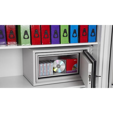 Ein geöffneter grauer Tresor steht in einem Regal mit bunten Aktenordnern und ist mit CDs und Kassetten bestückt.