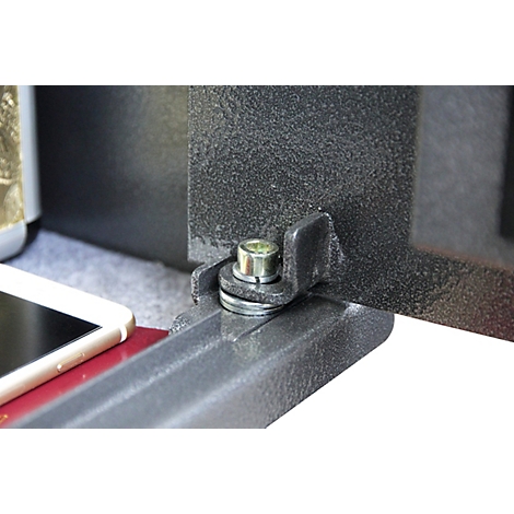 Nahaufnahme eines metallischen Scharniers an einem schwarzen Tresor mit einem Smartphone daneben.