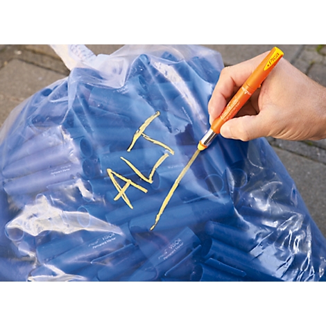 A hand writes the word "ALT" with an orange pen on a blue bag.