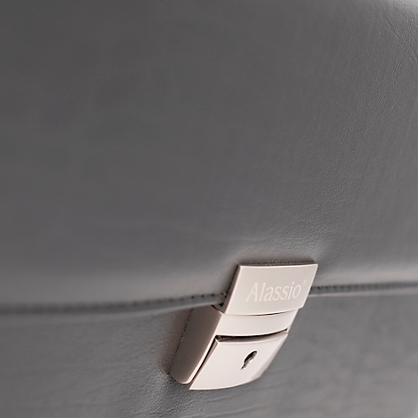Detailaufnahme einer grauen Ledertasche mit silbernem Schloss, auf dem "Alassio" steht.