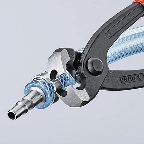 Gros plan sur une pince connectant un tuyau à un connecteur métallique. Le texte "KNIPEX" est visible sur la pince.