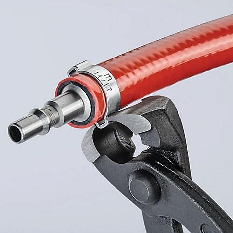 Gros plan d'une conduite de tuyau rouge avec un collier de serrage fixé avec une pince.