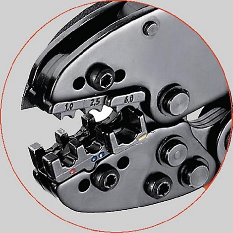 Gros plan d'une pince à sertir, de couleur argentée, avec des mâchoires ouvertes. Inscription : 1.0, 2.5, 6.0.