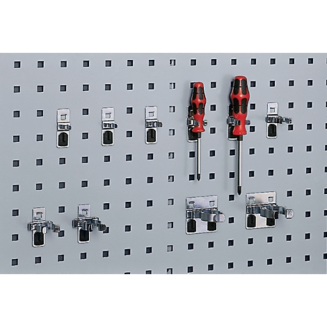 Panel perforado gris con destornilladores y soportes. Dos destornilladores, rojo-negro, en soportes.