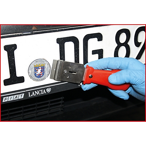 Hand mit blauem Handschuh hält Schaber an Kfz-Kennzeichen mit "Hessen"-Logo. Rotes Griffstück, Kennzeichen mit Schriftzügen, schwarzer Untergrund.