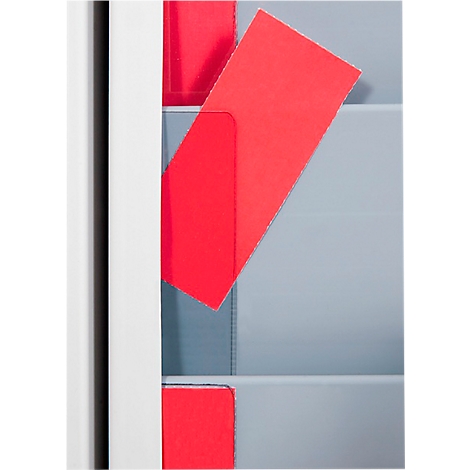 Overhead view of a storage system with red cards. One card lies diagonally in a compartment.