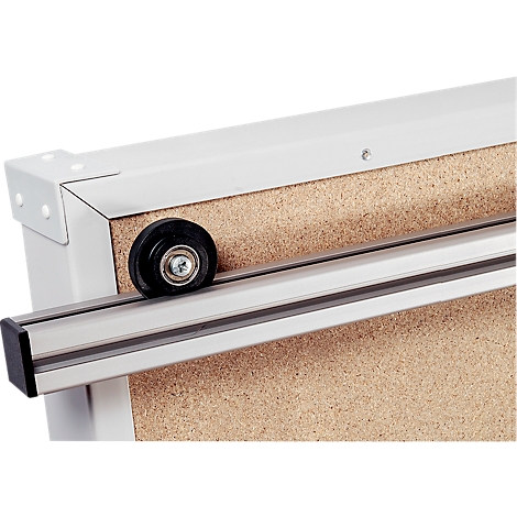 Close-up of a corner of a wooden board with a rail and roller system.