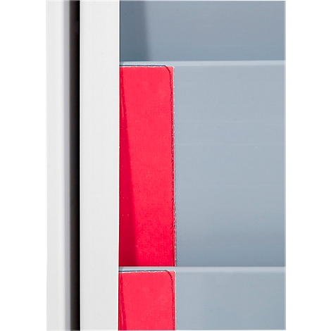 Red paper stacks between gray and white surfaces. Minimalist design.