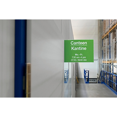 Panneau de cantine vert avec texte blanc sur un mur blanc. Les horaires d'ouverture sont mentionnés.