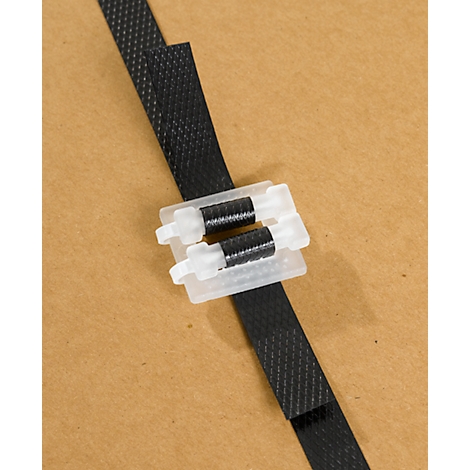 Black plastic strap with white clasp on brown background.