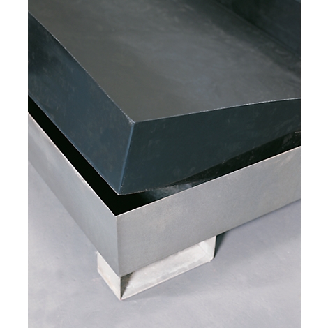 Gros plan d'un objet design avec une surface sombre et rectangulaire sur une base argentée brillante.