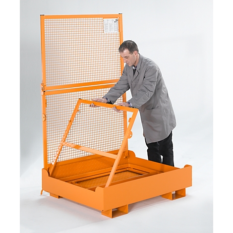 Un homme en blouse grise ouvre une cage grillagée orange.