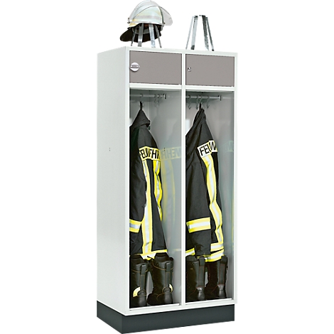A locker for the fire department with protective clothing, boots and helmet. Two compartments, white with a gray lid. The clothing is black and yellow.