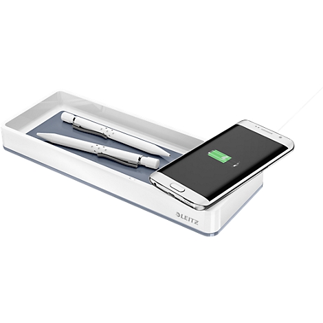 Station de charge avec stylos et smartphone. Batterie en charge, indicateur vert.