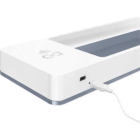 Gros plan d'un chargeur blanc avec un câble USB. Un symbole de chargement sans fil est représenté.