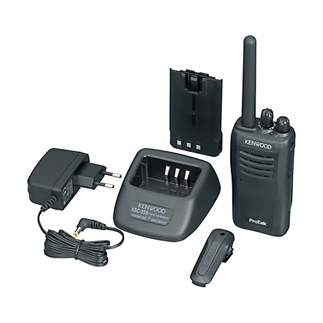 Zwarte Kenwood-radio met oplader, voedingsadapter, batterij, riemclip. Radio met antenne, knoppen. Opschrift: Kenwood, ProTalk.