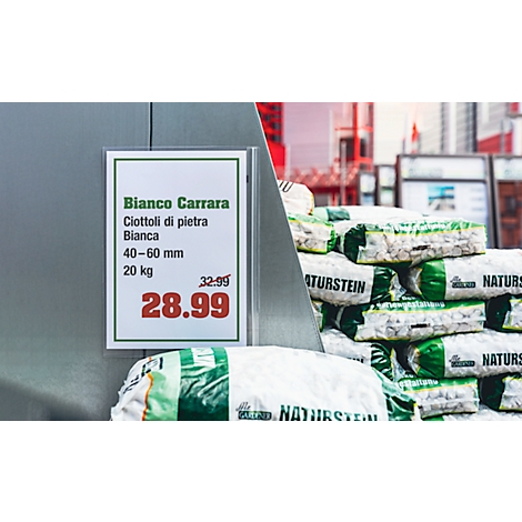 Panneau avec informations sur le produit : "Bianco Carrara" avec prix. Derrière, des piles de pierres dans des emballages plastiques.