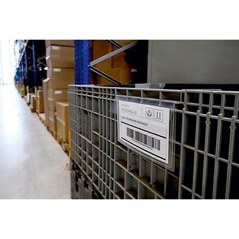 Gros plan d'une caisse de marchandises avec étiquette dans un entrepôt. L'étiquette affiche un code-barres et des informations pertinentes.