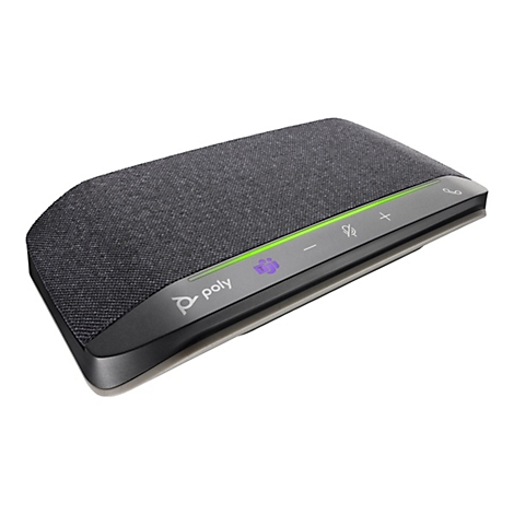Téléphone de conférence Poly gris foncé posé sur fond blanc. Il a une surface en tissu et des éléments de contrôle.