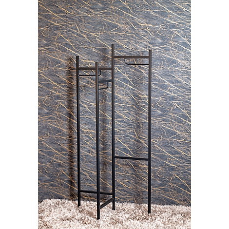 Porte-vêtements en métal noir sur fond gris. Debout sur un tapis clair.