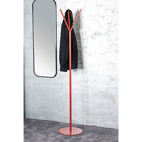 Porte-manteau rouge avec manteau noir, à côté d'un miroir noir sur un mur gris.