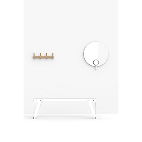 Couloir blanc avec porte-manteaux, miroir et banc contre un mur blanc.