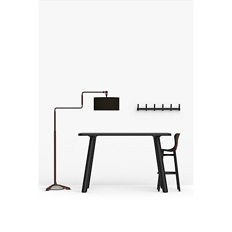 Table haute noire avec chaise, lampe et crochets muraux sur fond blanc.