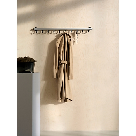 Porte-manteau mural. Trench-coat marron suspendu à des crochets, clés à côté.