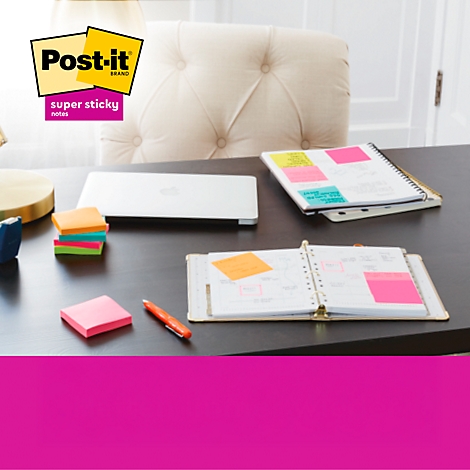 Gelber Post-it-Block neben Notizzetteln in Pastellfarben.