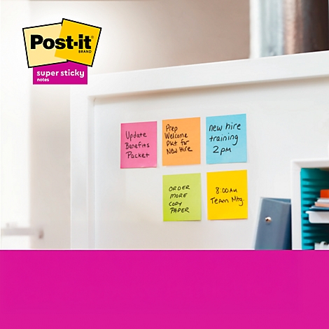 Schreibtisch mit Post-it Zetteln und Notizbüchern. Ein Laptop und ein Stift liegen ebenfalls dort. Der Text "Haften immer wieder" ist unten zu sehen.