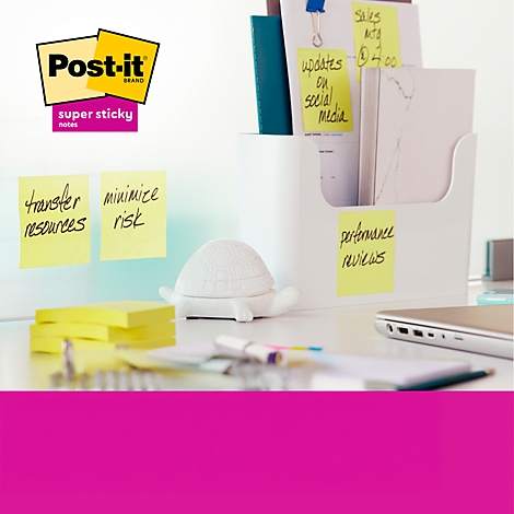 Büro-Schreibtisch mit Post-it-Zetteln, Notizen mit Schriftzügen, Stifthalter, Schildkröten-Dekor und Laptop.