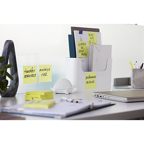 Configuration de bureau avec des notes, des dossiers, un ordinateur portable et un décor. Notes adhésives jaunes avec des notes telles que "Transfert de ressources".