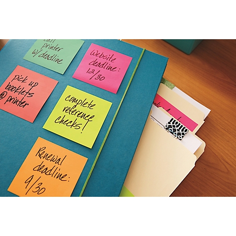 Close-up van een blauwe map met plaknotities en een open bestand. Notities geven deadlines en taken aan.