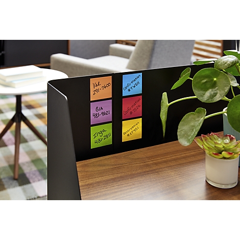 Desk with various colored sticky notes. Some notes show names and numbers, others show 'confirmation' with hashtags. Plants left and right.
