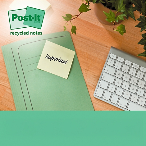 Gele Post-it briefje met het woord 'important' op een groene map, naast een toetsenbord en plant.