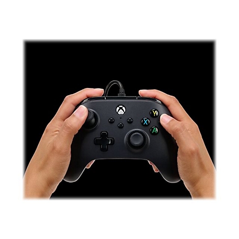 Person hält einen schwarzen Xbox-Controller. Auf dem Controller sind Knöpfe mit Buchstaben und Farben zu sehen.