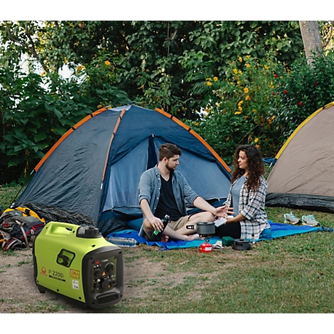 Ein Paar beim Camping vor einem Zelt mit einem grünen Stromerzeuger im Vordergrund.