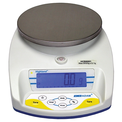 Digital scale with round weighing element. The display shows 0.0 g. Inscription: Highland, ADAM.