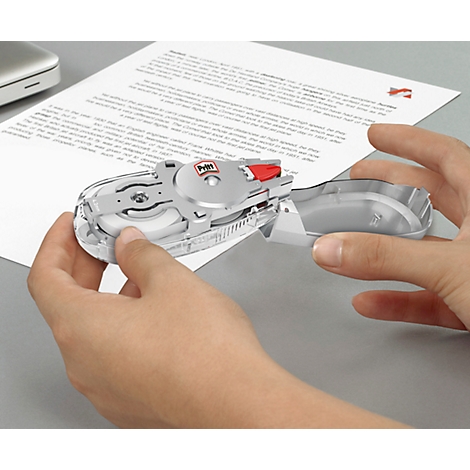 Hands holding a silver correction roller over a white sheet. The roller says "Pettit".