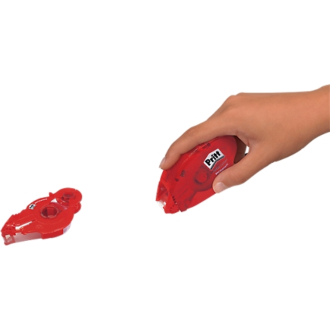 A hand holds a red Pritt glue stick. Another glue stick lies on a white background to the right.