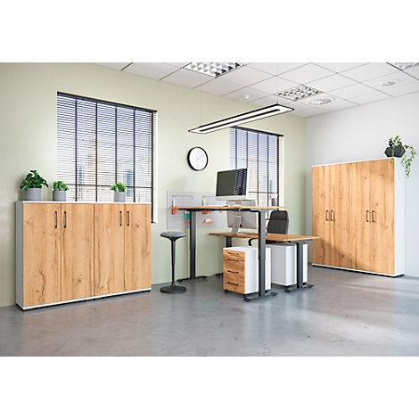Een kantoorruimte met houten kasten en bureau. Een kast rechts, een kast links en een zit-sta combinatie.