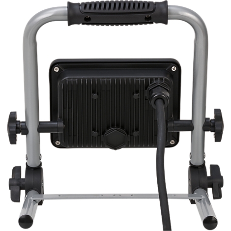 Un projecteur portable avec un cadre en métal argenté robuste et un boîtier de lampe noir à l'arrière. Le câble est connecté sur le bas à gauche.