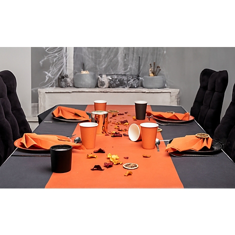 Festlich gedeckter Tisch mit orangefarbenen Akzenten, Gläsern, Servietten und Dekoration.