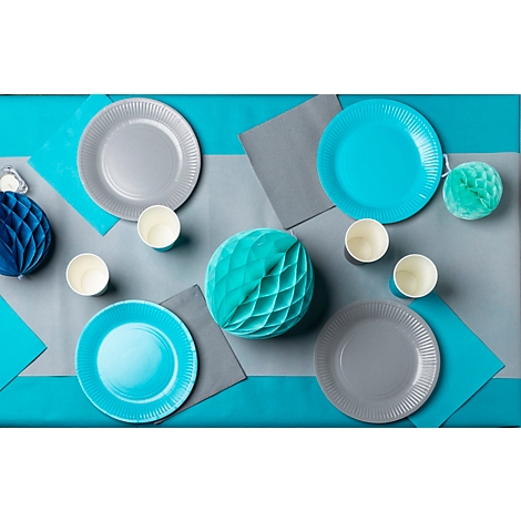 Hellblauer Tisch mit Partydeko: Teller, Becher, Servietten, Papierkugeln.