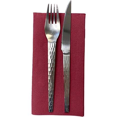 Gabel und Messer auf rotem Stoff. Besteck aus Metall mit Hammerschlagmuster.