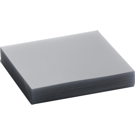 A stack of gray sheets, presumably paper or film, lying on a light surface.