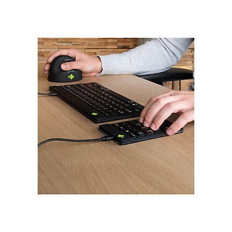 Person verwendet eine ergonomische Vertikalmaus und eine geteilte, kompakte Tastatur an einem Holztisch.