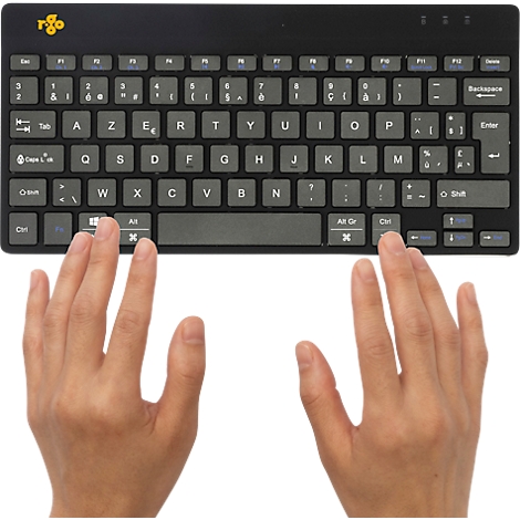 Eine Person benutzt eine schwarze Tastatur mit grauen Tasten. Die Hände sind sichtbar.