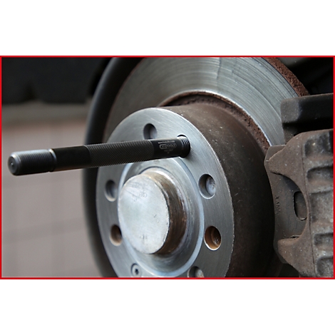 Detailaufnahme einer Bremsscheibe mit Werkzeug, das in eine Schraubenbohrung eingesetzt wird.